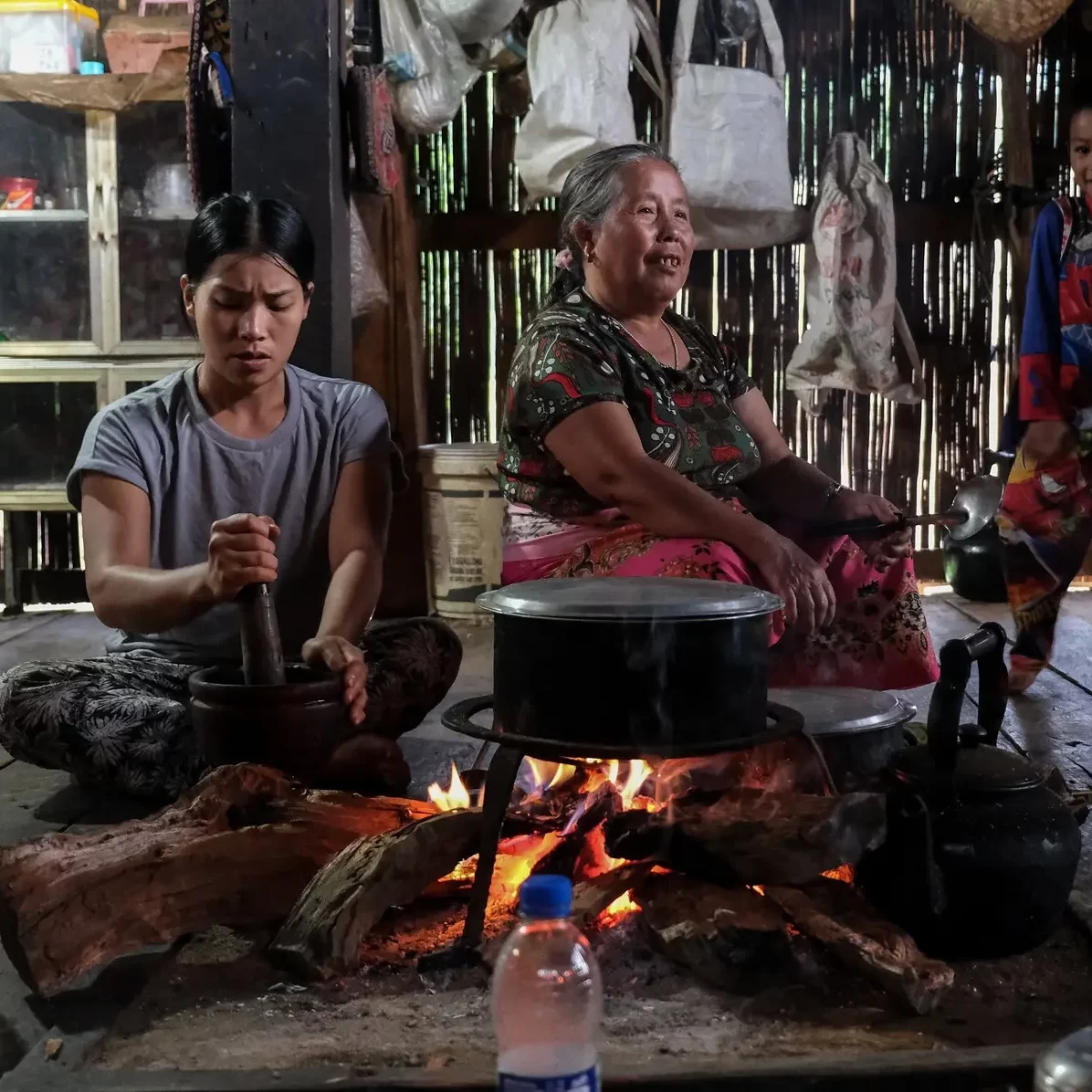 Two Lahu women at a fire.